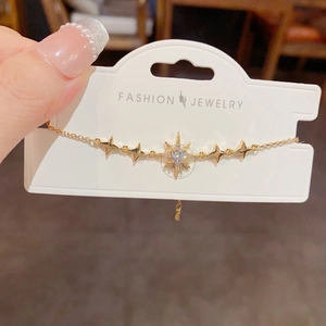 Bracelet à breloques étoile dorée avec zircons brillants sur carte de présentation