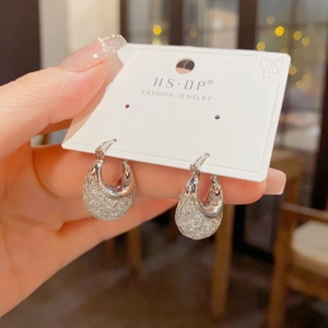 Nahaufnahme eleganter U-förmiger Silber-Ohrringe mit glitzernden Kristallen