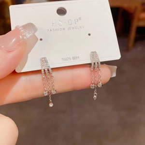 Detalle de pendientes de borlas de tres filas con circonitas y agujas de plata S925