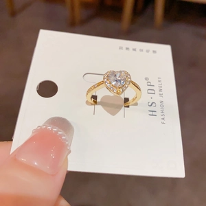 Bague coeur dorée de luxe avec pavé de diamants sur une carte de présentation