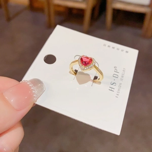 Gros plan d'une bague avec pierre précieuse rouge en forme de cœur et diamants en or