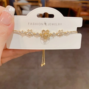 Close-up of golden cherry blossom bracelet with zircon inlay and adjustable chain