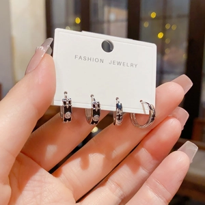 Detailopname van zilveren oorbellen met zwart emaille en fonkelende diamantaccenten