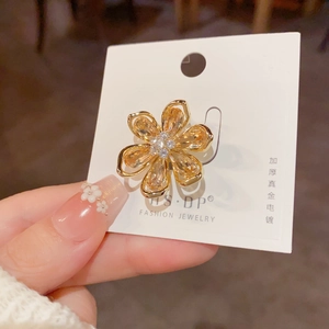 Détail de la broche fleur dorée avec cristaux ambrés et centre en diamants étincelants