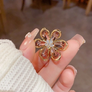 Vue détaillée d'une broche fleur en cristal ambré avec dorure et zircons au centre