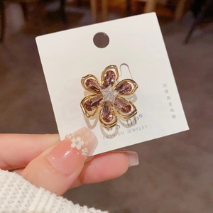 Vue détaillée d'une broche fleur à six pétales avec cristaux roses et placage en or