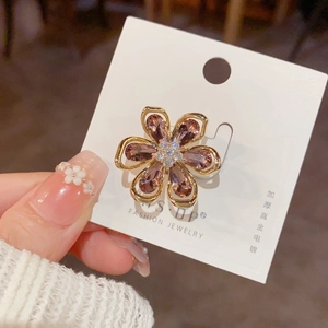 Détail de la broche fleur en cristal rose avec placage or et zircons sur carte