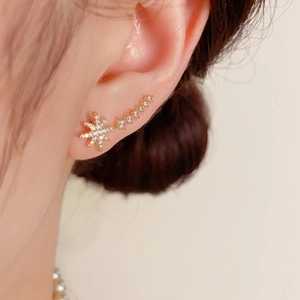 Macro view of gold star crawler earrings with white cubic zirconia stones