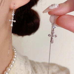 Détails de longues boucles d'oreilles pompon avec croix en zircon et chaîne fine