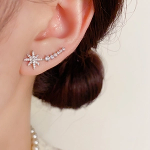 Macro shot of silver star ear crawler with sparkling zircons on female ear
