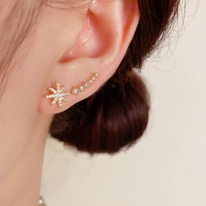 Macro side view of a gold star ear cuff featuring shimmering white cubic zirconia accents