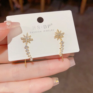 Detail of star-shaped tassel earrings with gold plating and sparkling zircon stones