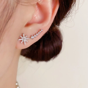 Elegant silver star crawler earrings with cubic zirconia stones worn on the earlobe