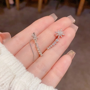 Sparkling silver star crawler earring with rhinestones held in hand with knit sleeve