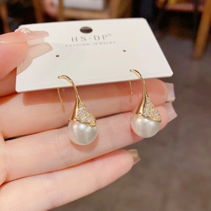 Vista de detalle de pendientes de perlas lágrima de lujo con pavé de circonitas
