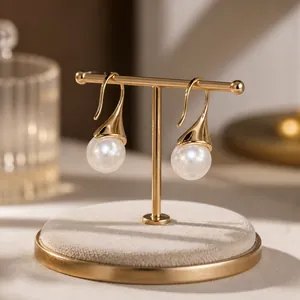 Detalle de pendientes colgantes en oro de 14K con perlas blancas y circonitas brillantes