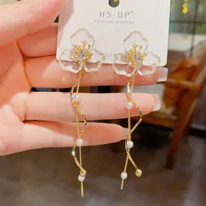 Detalle de los pendientes largos de plata S925 con pétalos de flores transparentes