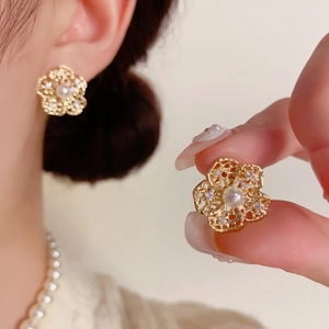Elegant gold hollow flower stud earrings with pearl center and zircon details for women