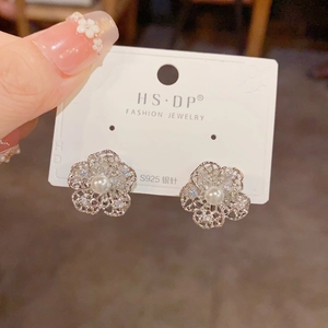 Detailed view of silver hollow flower stud earrings with center pearl and S925 silver needles