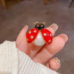 Cute red ladybug brooch with white pearl and sparkling crystals on golden metal base