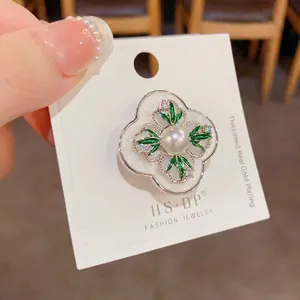 Elegant four-leaf flower brooch with green enamel, pearl accent and gold plating