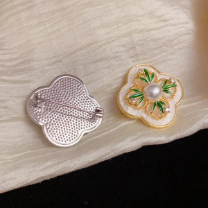 Detailed front and back views of flower brooch with pearl, zircon and safety pin closure