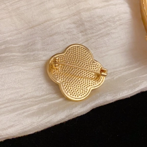 Elegant gold clover brooch with intricate textured back and pin clasp for women