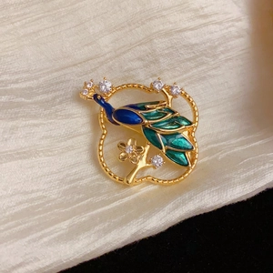 Detailed close-up of peacock brooch with blue enamel and sparkling rhinestones
