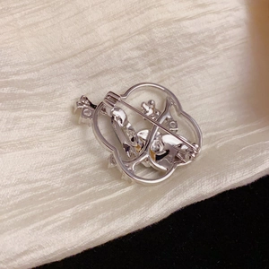 Elegant hollow floral brooch in silver metal with peacock leaf patterns and safety pin