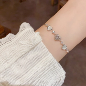 Close-up of adjustable heart bracelet with zircon and cat-eye stones on wrist