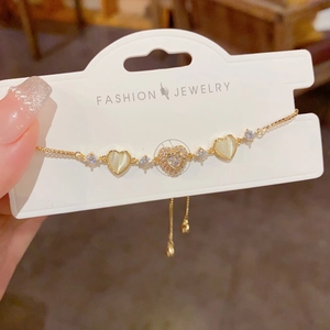 Macro shot of gold-plated heart bracelet with zircon stones and adjustable pull chain