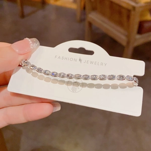Close-up of elegant silver bracelet with oval zircons on a fashion jewelry card