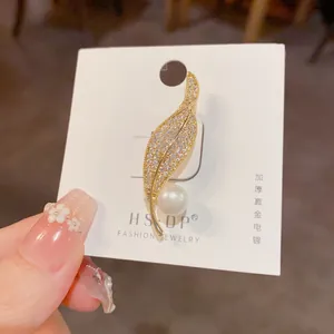 Detailed close-up of leaf brooch with thick gold plating and micro-pave cubic zirconia