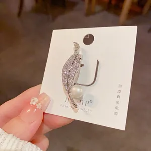Elegant leaf brooch featuring micro-set cubic zirconia and a round white pearl