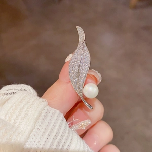Elegant silver leaf brooch with sparkling zircons and a large round white pearl pendant