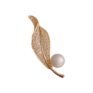 Elegant gold leaf brooch featuring micro-set cubic zirconia and a large white pearl accent
