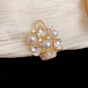 Close-up of golden flower basket brooch with white pearls and sparkling zircon accents