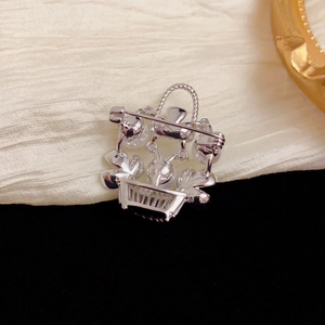 Silver flower basket brooch with pearls and rhinestones on elegant silk background