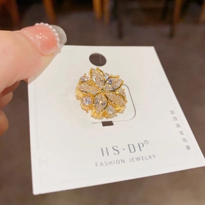 Nahaufnahme der vergoldeten Blumenbrosche mit Zirkonia Kristallen auf einer Displaykarte