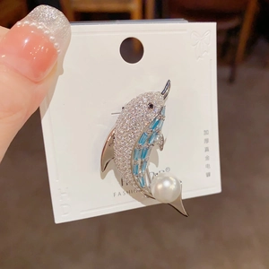Detail of dolphin brooch featuring micro-set zircons, blue gems and a white pearl accent