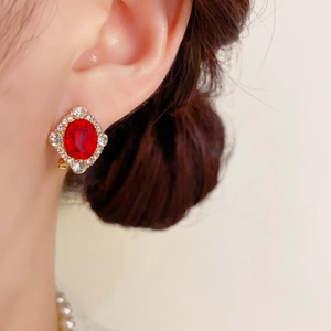 Gros plan sur la boucle d'oreille rétro en or avec cristal rouge et halo de strass