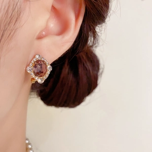 Gros plan d'une boucle d'oreille vintage en or avec cristal violet et strass