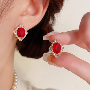 Boucles d'oreilles vintage en or avec gemme rouge ovale et entourage de diamants