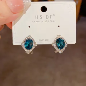 Gros plan de boucles d'oreilles vintage en cristal bleu avec tige en argent S925 sur carte