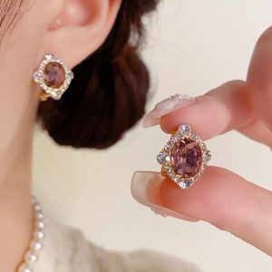 Détail du clou d'oreille vintage en forme de losange avec cristal mauve et diamants