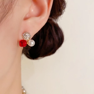 Detailansicht quadratischer roter Kristallohrring mit Perle und Diamanten am Ohr