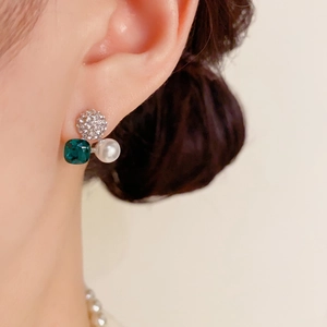 Elegante Ohrstecker mit Smaragdkristall, Perlen und Diamantbesatz am Ohr
