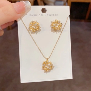 Detail of luxury gold jewelry set featuring snowflake design with pearls and zircons