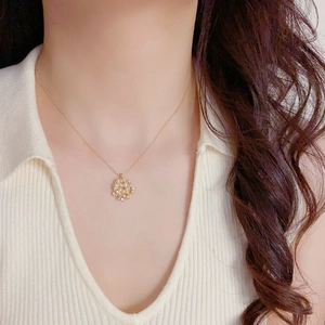 Elegant gold necklace with pearl and crystal firework pendant on a female model