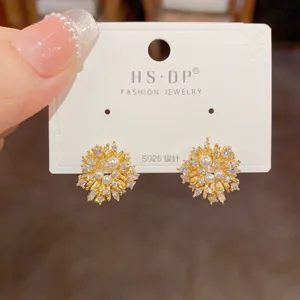 Close-up of gold fireworks earrings with pearls and zircon on S925 silver needles
